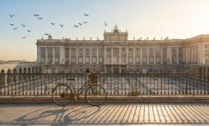 Grand Spanish castle wedding venue near Madrid featuring a royal banquet setup on a high terrace with dramatic mountain sunset views