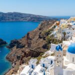 conic Oia Santorini cliffside with blue-domed churches and white houses.